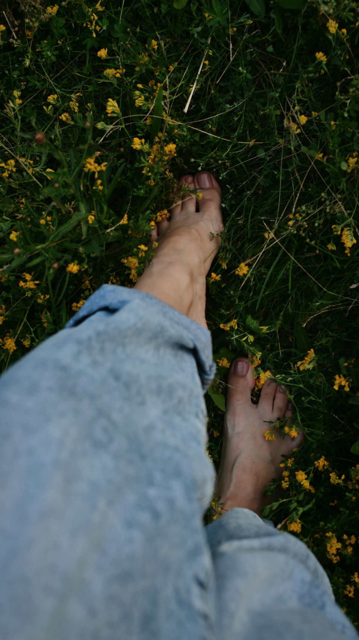 Blote voeten die vrij door een bloemenweide lopen