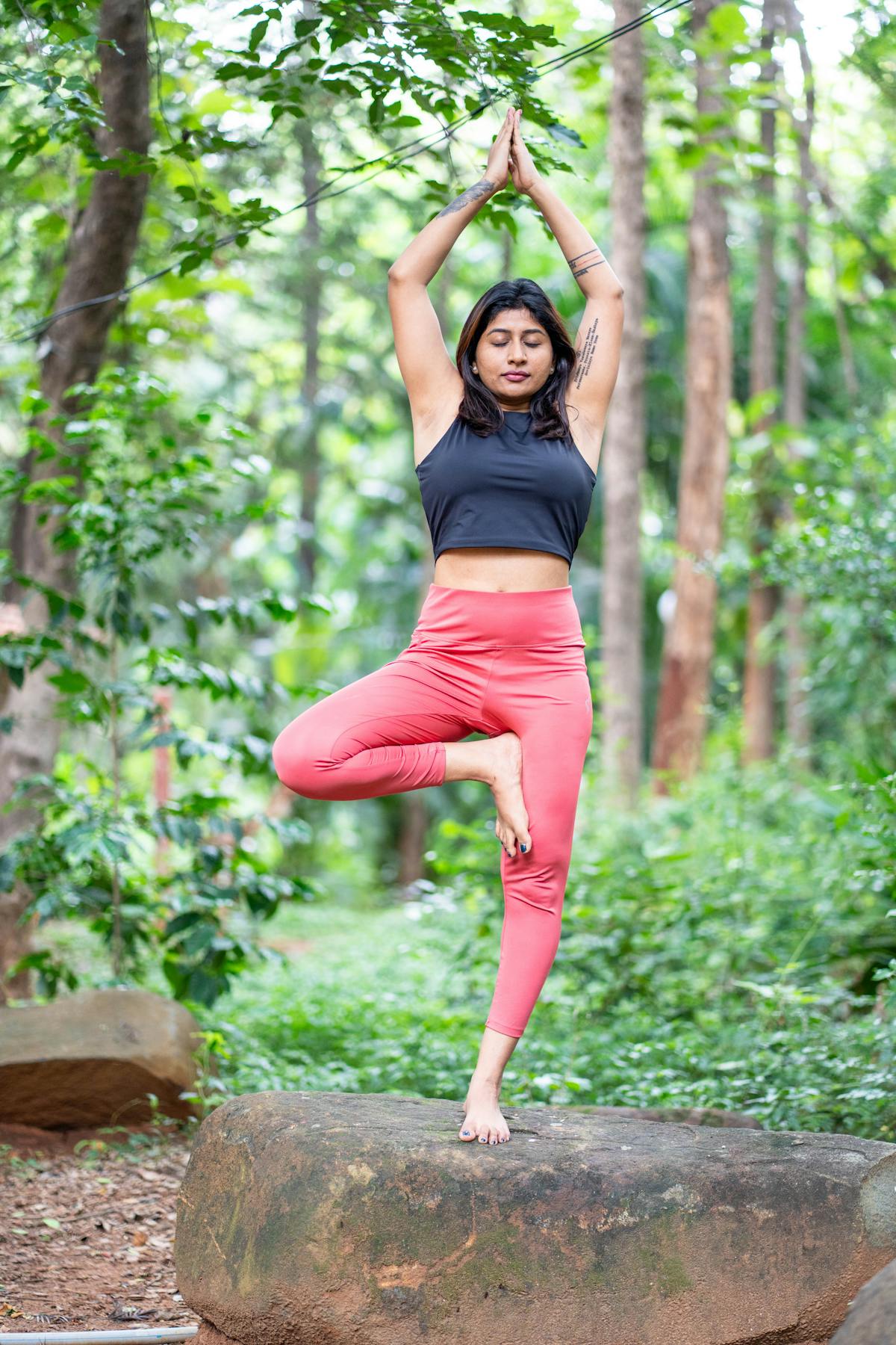 Vrouw die yoga beoefent in een groen bos
